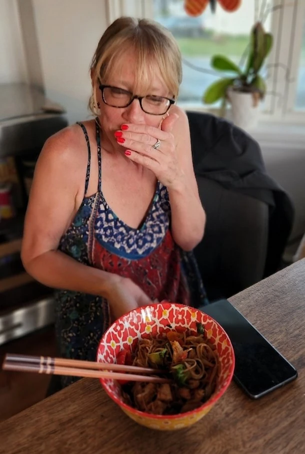 Chef Kate enjoying a homemade noodle bowl at her kitchen table